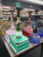 Colorful Starbuzz hookahs displayed on table inside One Stop Smoke Shop Houston